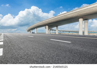 Asphalt highway and bridge under blue sky - Shutterstock ID 2140565121