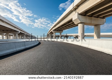 Asphalt highway and bridge under blue sky