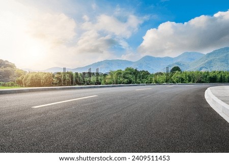 Asphalt highway road and green forest with mountain natural landscape under blue sky