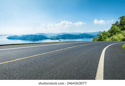 Asphalt highway road and lake with islands nature landscape on a sunny day. Beautiful coastline in summer season. - Powered by Shutterstock