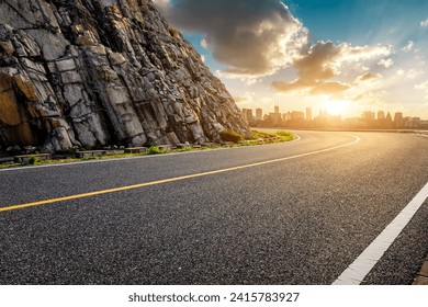 Asphalt highway road and mountain with city skyline at sunset - Powered by Shutterstock