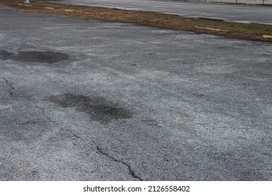 Asphalt parking lot that needs repairs, Badly damaged asphalt pavement, asphalt seams, pothole patch, potholes