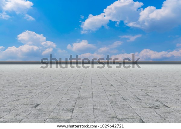 Asphalt pavements and square floor tiles under the blue\
sky and 