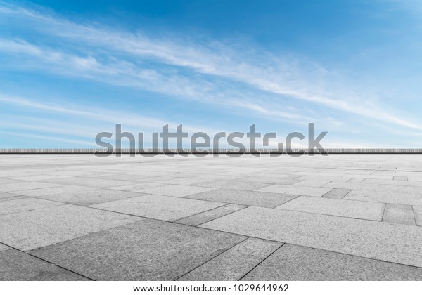 Asphalt pavements and square floor tiles under the\
blue sky and white\
clouds