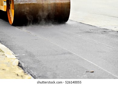 Asphalt Paving With A Steel Wheel Roller. Steam Coming Out From Asphalt.