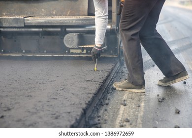  Asphalt Paving Works. Road Worker Checks The Depth Of Paving The Roadway