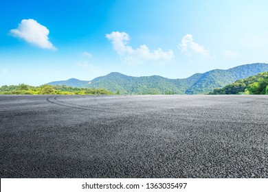 Asphalt race track ground and mountains with blue sky landscape - Powered by Shutterstock