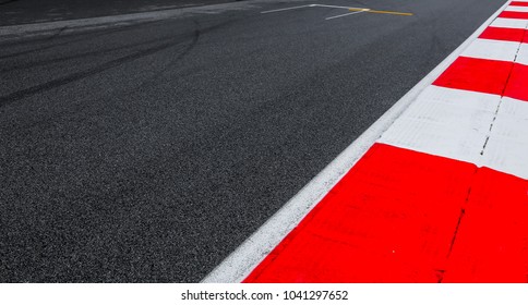 Asphalt Red And White Kerb Of A Race Track Detail. Motorsports Racing Circuit Close Up.