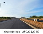 Asphalt road after laying asphalt. New asphalt road renovation. Road construction. Paved highway. Black tarmac road after rebuilding, repair, renovation. Black tarmac rebuilding. Street Asphalting.