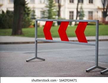 asphalt road with arrow fluorescent light signs and city background.