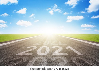 Asphalt Road With Arrow Guideline And 2021 Letters Painted On The Surface. Concept For Success In The Future Goal And Passing Time. Happy New Year