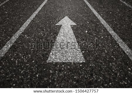 Asphalt road with an arrow pointing forward on the surface. An image of a milestone roadmap is a representation of success in the future goal