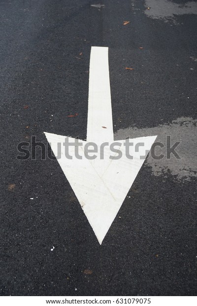 Asphalt road. Arrow sign on\
asphalt