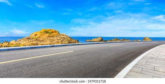 Asphalt road and beautiful seaside scenery under blue sky. - Shutterstock ID 1979311718