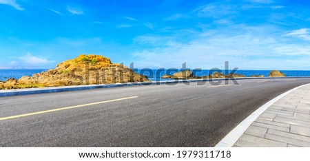 Asphalt road and beautiful seaside scenery under blue sky.