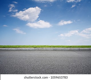 Asphalt road and blue sky above green grass - Powered by Shutterstock