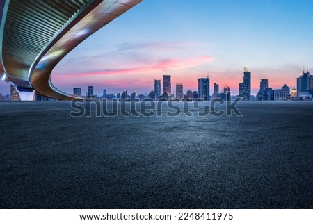 Asphalt road and bridge with city skyline in Shanghai at sunset, China. 