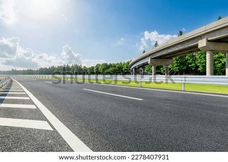 Asphalt road and bridge with green forest background