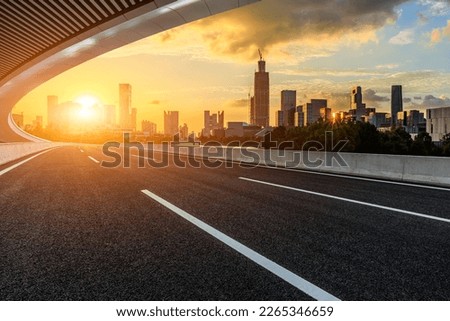 Asphalt road and bridge with modern city skyline at sunset in Ningbo, Zhejiang Province, China. 