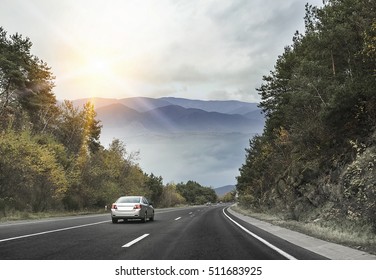 Asphalt road and cars in the mountains with cloudy sky on the background. - Powered by Shutterstock