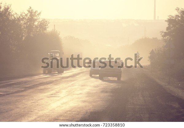 Asphalt road\
with cars at sunset at countryside. Concept of bad road, unhappy\
trip and sad to leave.Blurred\
photo