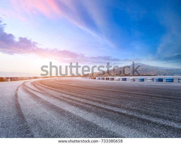 Asphalt road\
circuit and hill under the blue\
sky