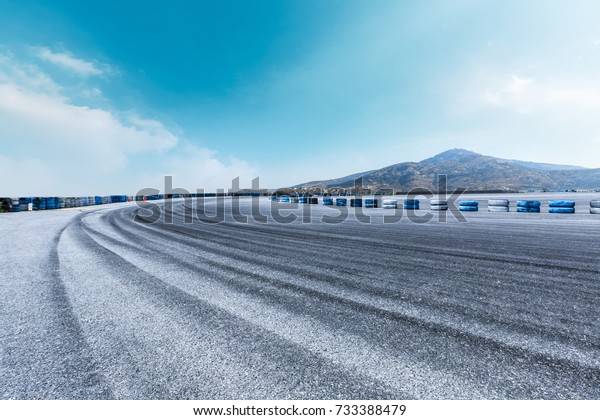 Asphalt road\
circuit and hill under the blue\
sky