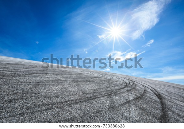 Asphalt\
road circuit and sky clouds with car tire\
brake