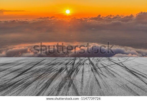 Asphalt road circuit with tire skid marks and sky\
sunset with car tire\
brake.