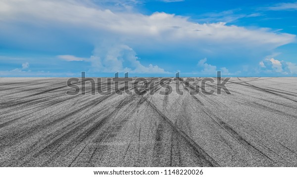 Asphalt road circuit with tire skid marks and blue\
sky with car tire\
brake.