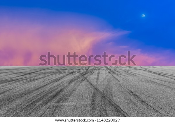 Asphalt road circuit with tire skid marks and\
twilight sky with car tire\
brake.