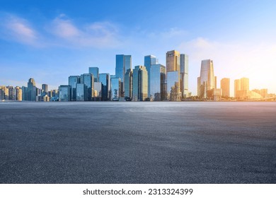 Asphalt road and city buildings at sunrise - Powered by Shutterstock
