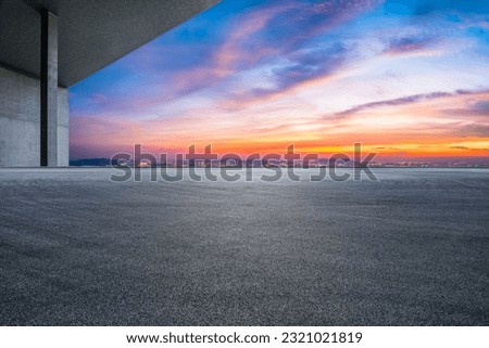Asphalt road and city skyline with colorful sky clouds at sunset