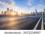 Asphalt road and city skyline with modern buildings in Chongqing at sunrise.