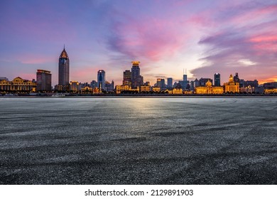 Asphalt road and city skyline with modern commercial buildings in Shanghai at night, China.