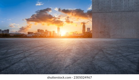 Asphalt road and city skyline with modern buildings at sunset 