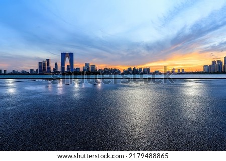 Asphalt road and city skyline with modern building at sunset in Suzhou, China. 