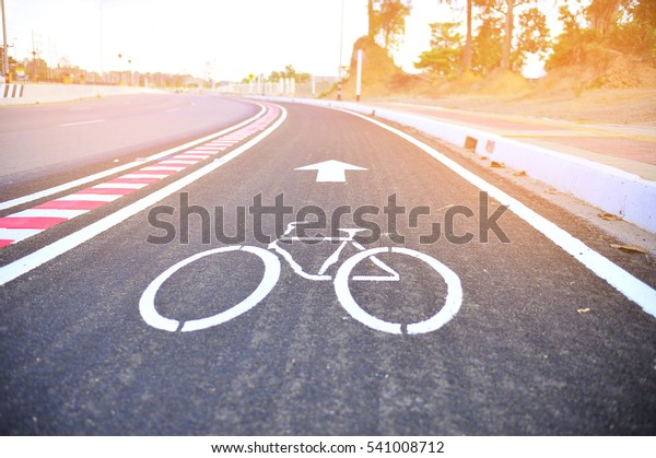 Asphalt road\
with cycle track and bike\
sign.\
\
