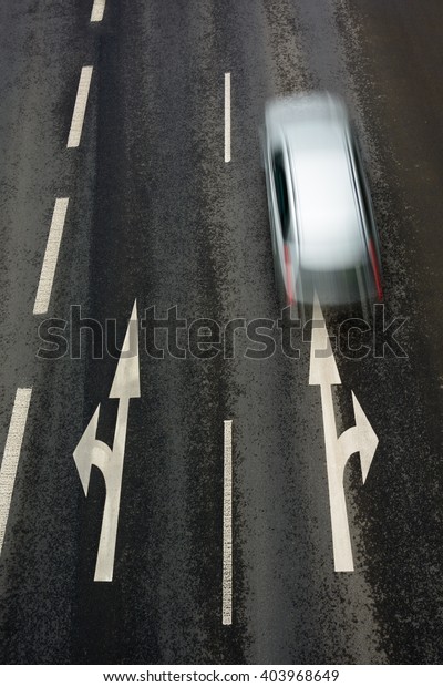 Asphalt road with\
dividing lines and car