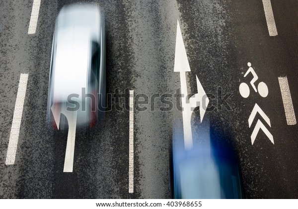 Asphalt road with\
dividing lines and cars