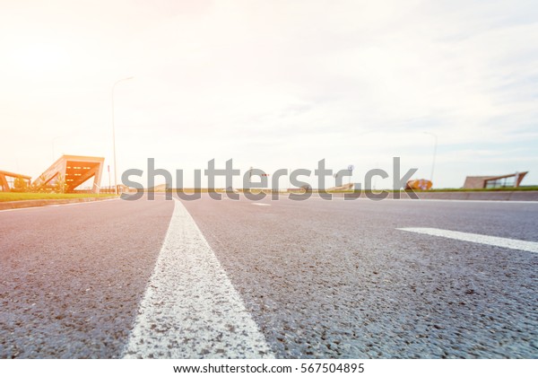 Asphalt road\
with a dividing strip in the\
sunlight