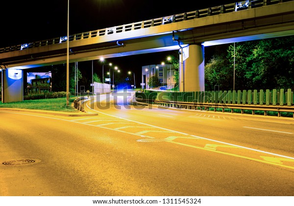 Asphalt road and Elevated Bridge at night with\
illuminating lamps