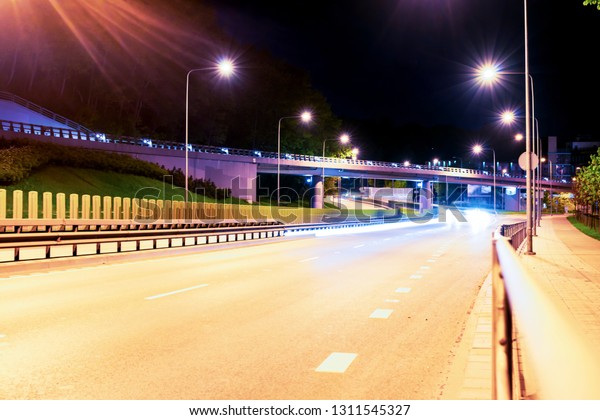 Asphalt road and Elevated Bridge at night with
illuminating lamps