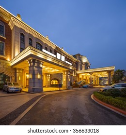 Asphalt Road Front Of Luxury Hotel In Clear Sky At Night