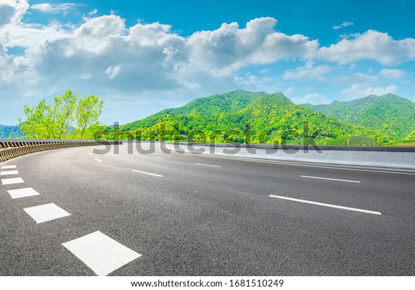 Asphalt road and green mountain nature landscape on\
sunny day.