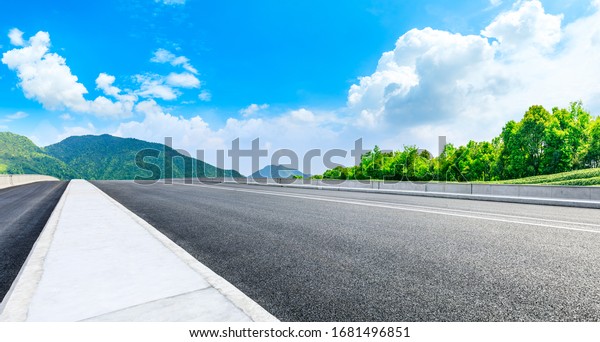 Asphalt road and green tea mountain nature\
landscape on sunny day,panoramic\
view.