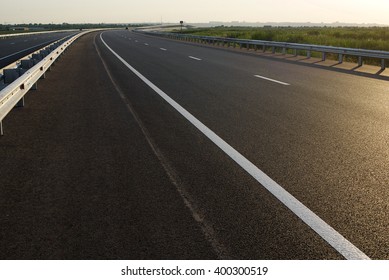 Asphalt Road High Way Empty Curved Road Clouds And Sky At Sunset