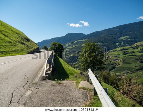 Asphalt road in\
Italy, Alps in a beautiful summer day, green grass, Dolomiti Alpes,\
Italy, September, 2017.