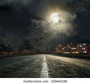 асфальтированная дорога, ведущая в город ночью