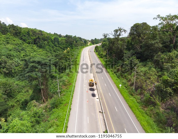 Asphalt road maintenance operator job by\
worker at Asian\
countryside